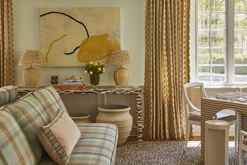 Pleated patterned lampshades on rattan lamps in a room layered with leopard, plaid, and stripe