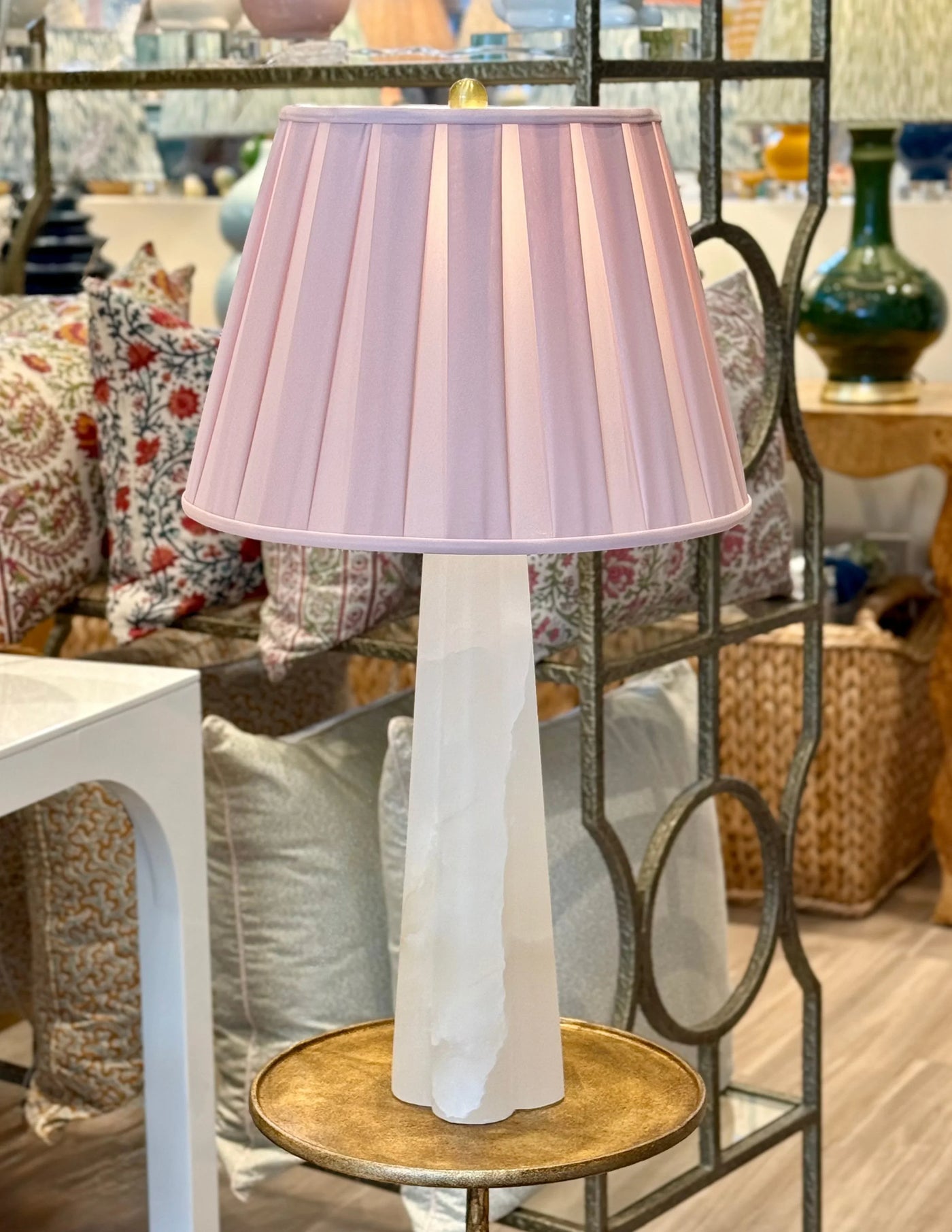 Alabaster table lamp styled with pink pleated shade on brass table