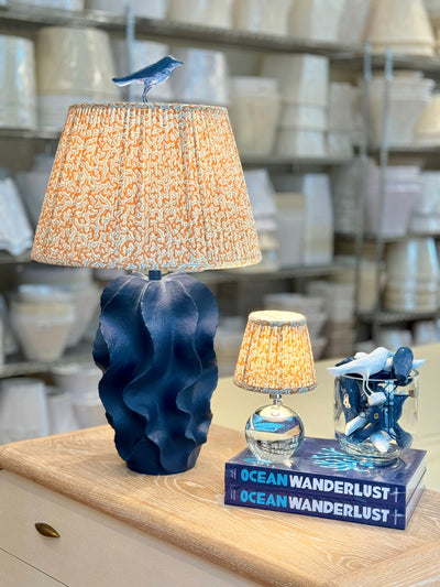 Blue lamp with orange lampshade and bird finial