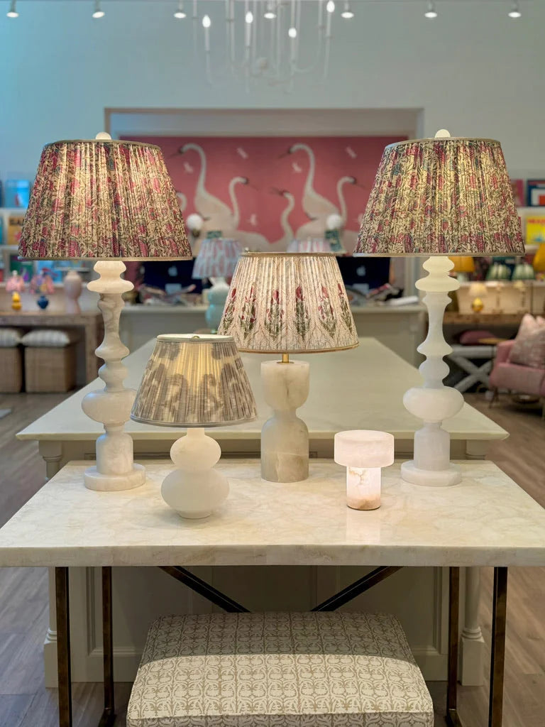 group display of alabaster lamps, large and small. Red & white flower block print lampshade featured in the middle. 