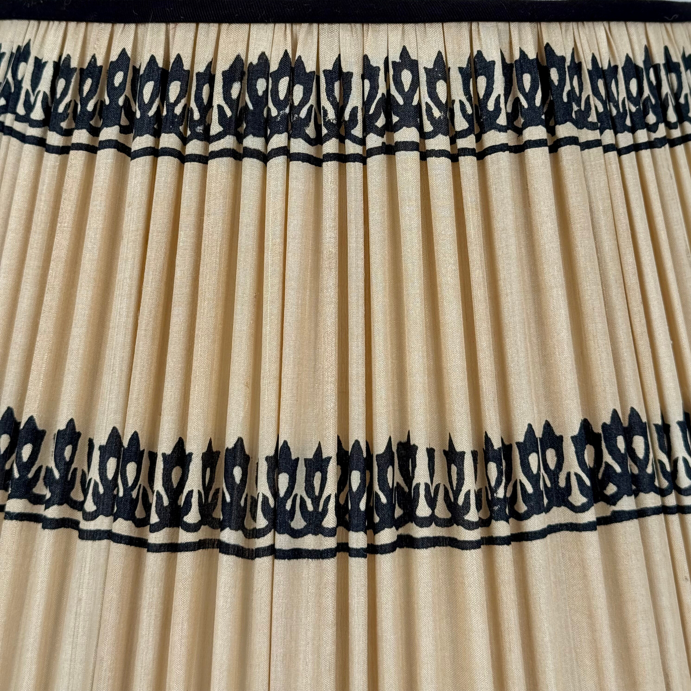 Beige pleated curtain with black decorative trim