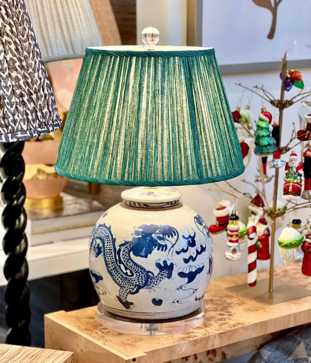 Luxury green Fermoie pleated empire lampshade displayed on a blue and white ginger jar lamp, offering a classic and timeless look for sophisticated interiors.