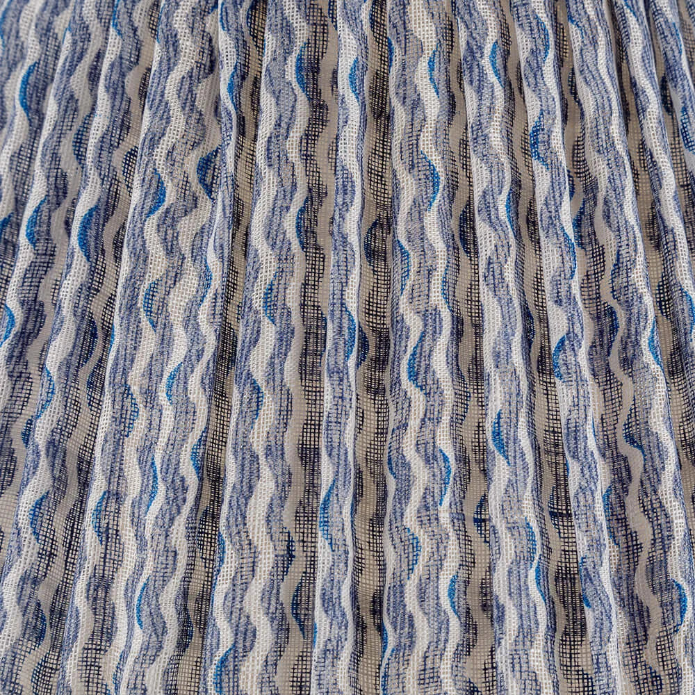 Close-up of Fermoie Blue Popple fabric with wavy blue and white pattern, showcasing luxury designer texture and pleated detailing