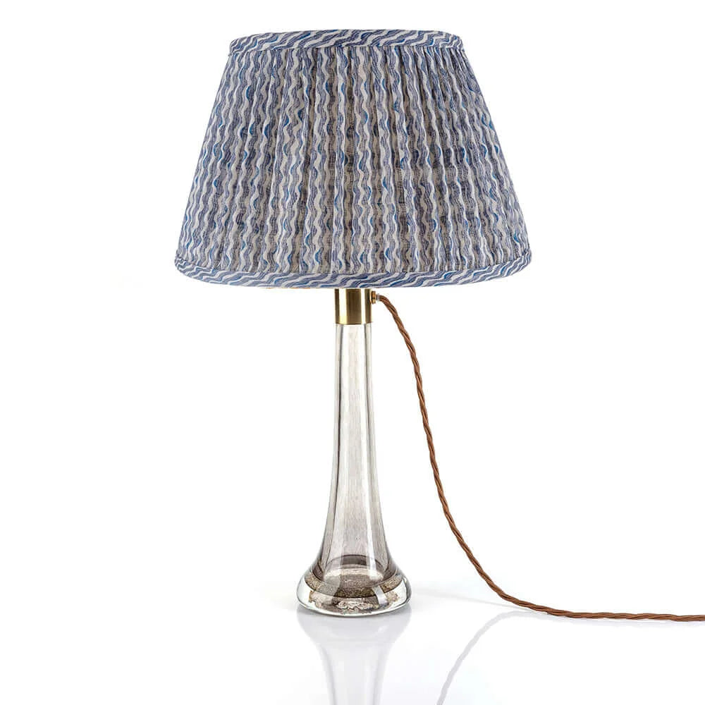 Luxury Fermoie Blue Popple gathered empire lampshade with wavy blue and white pattern, displayed on a clear glass lamp