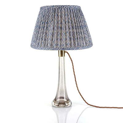 Luxury Fermoie Blue Popple gathered empire lampshade with wavy blue and white pattern, displayed on a clear glass lamp