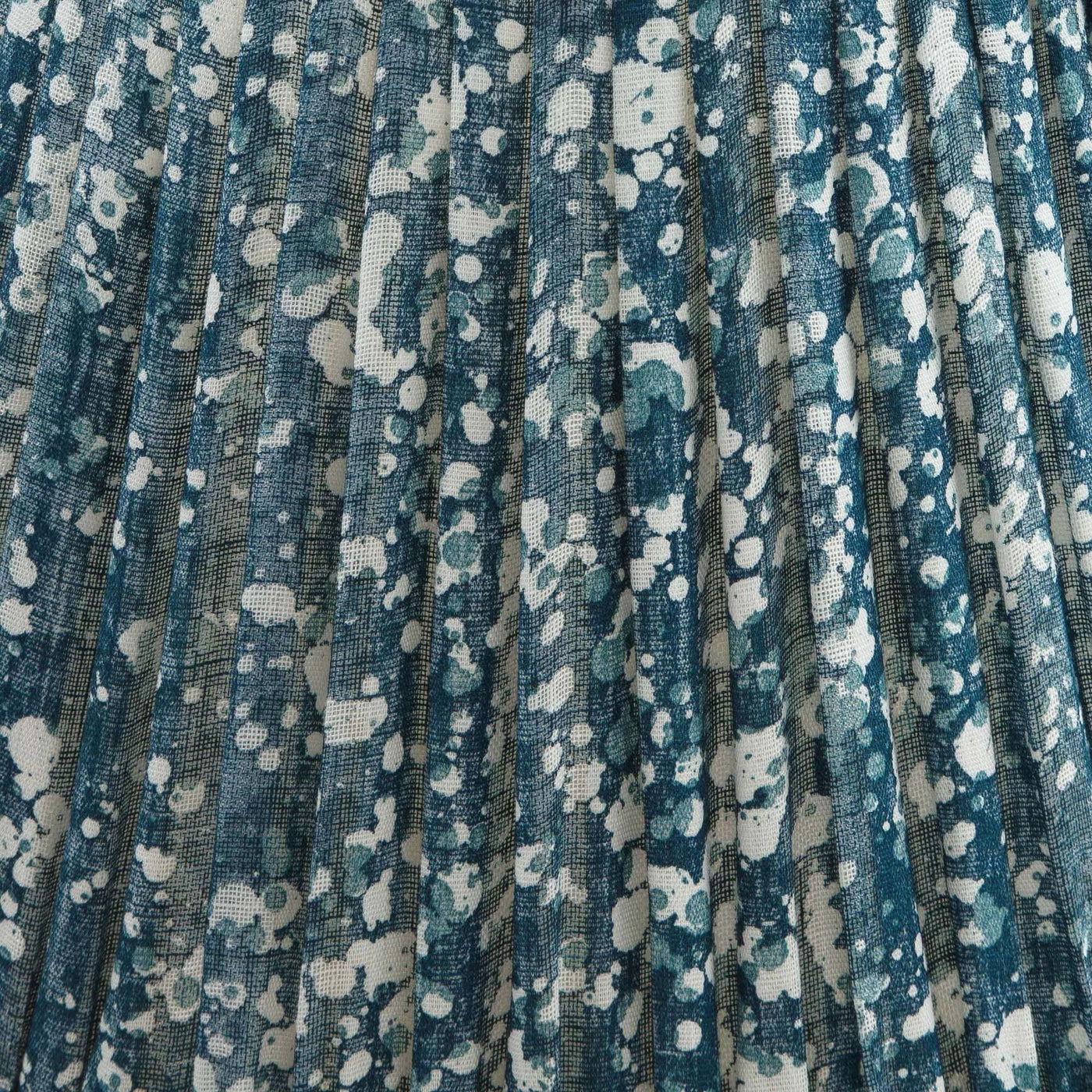 Close-up of luxury Fermoie Blue Quartz fabric with a speckled blue and white pattern, showing designer pleated detailing for high-end interiors