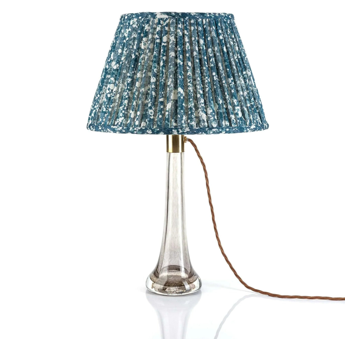 Luxury Fermoie Blue Quartz fabric with a speckled blue and white pattern, showing designer pleated detailing displayed on a clear glass lamp.