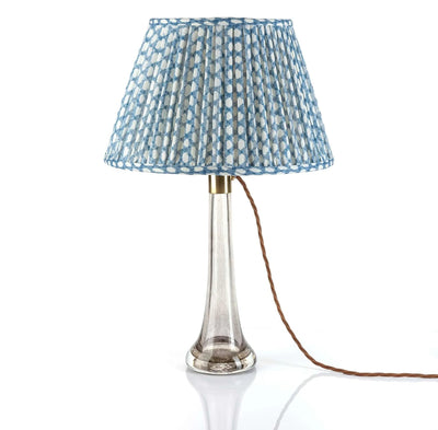 Luxury designer Fermoie Blue Wicker gathered empire lampshade with blue and white woven pattern displayed on a clear glass lamp