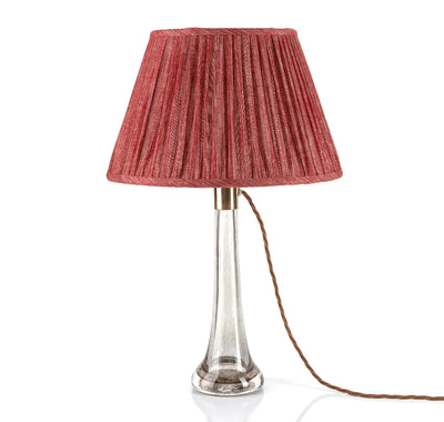 Luxury designer Fermoie Carpet Slipper gathered empire lampshade in a rich red hue, displayed on a clear glass lamp base.