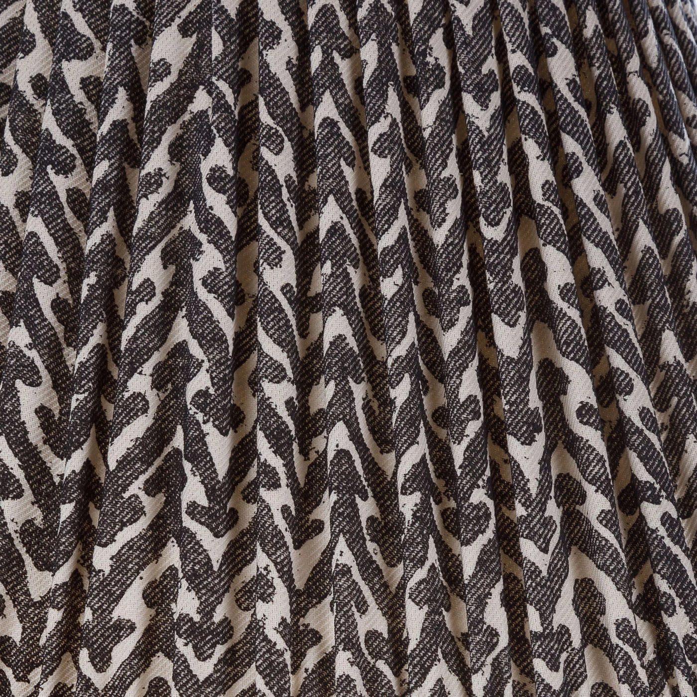 Close-up of Fermoie Charcoal Rabanna fabric with a textured charcoal and cream pattern and pleated detailing