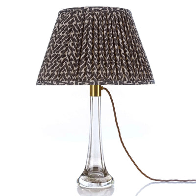 Designer Fermoie Charcoal Rabanna gathered empire lampshade, featuring a textured charcoal and cream pattern displayed on a clear glass lamp 