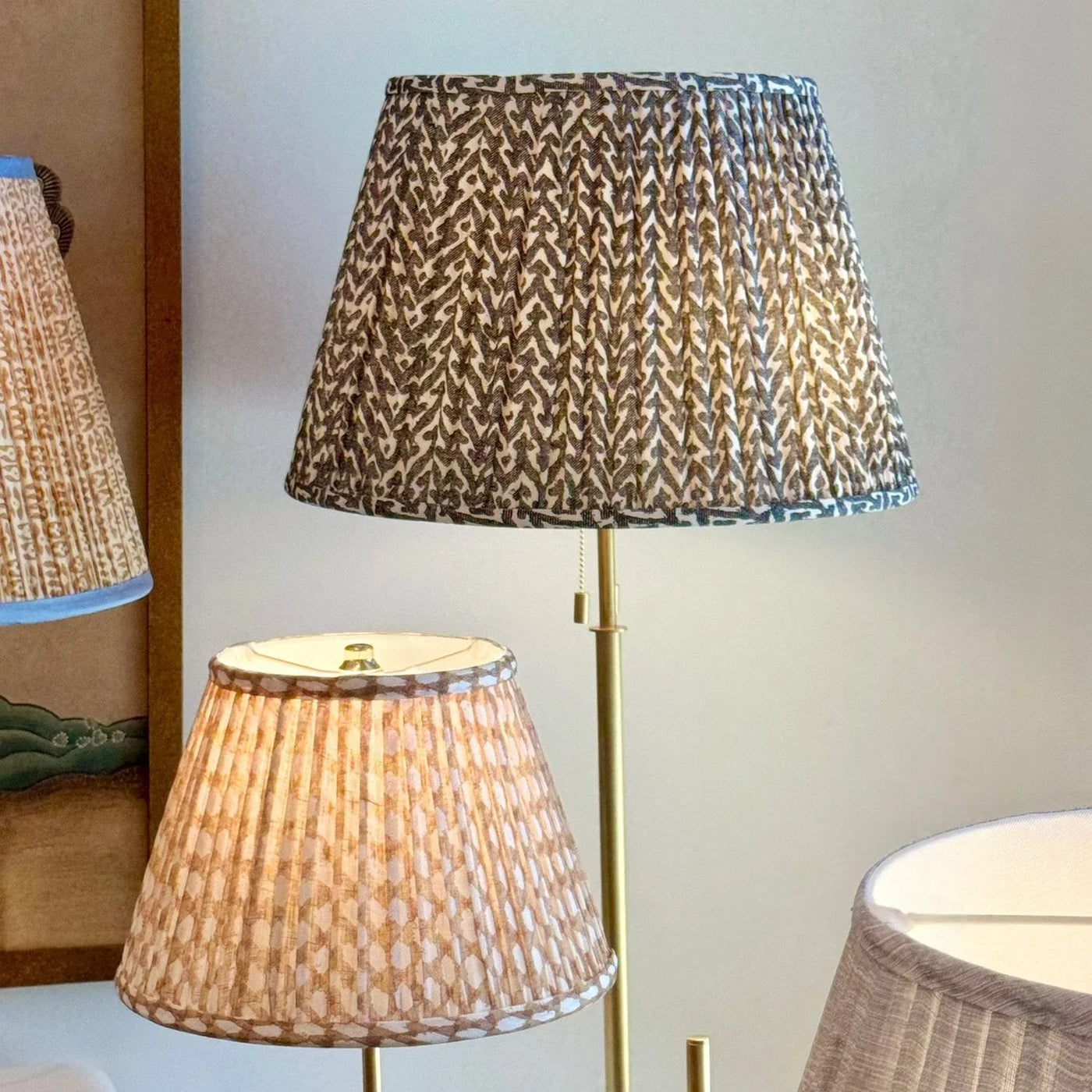 Designer Fermoie Charcoal Rabanna gathered empire lampshade, with textured charcoal and cream pattern displayed on gold floor lamp