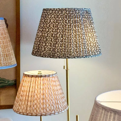 Designer Fermoie Charcoal Rabanna gathered empire lampshade, with textured charcoal and cream pattern displayed on gold floor lamp
