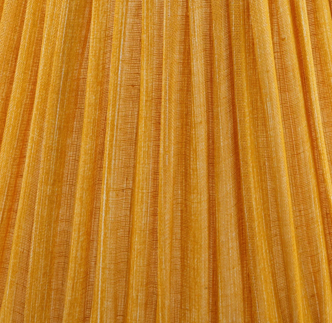 Close-up of Fermoie golden yellow fabric with pleated detailing, highlighting the rich texture and handcrafted quality
