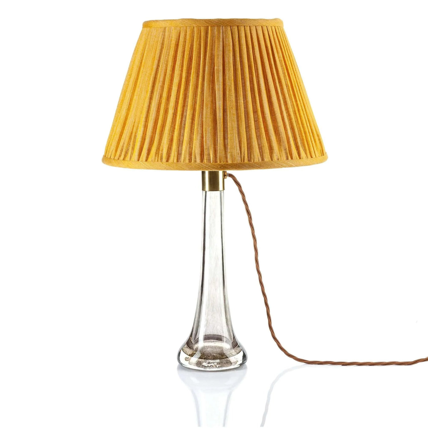 Luxury designer Fermoie gathered empire lampshade in golden yellow fabric with pleated detailing displayed on a clear glass lamp