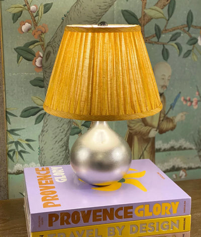 Luxury designer Fermoie gathered empire lampshade in golden yellow fabric with pleated detailing displayed on a mini silver lamp