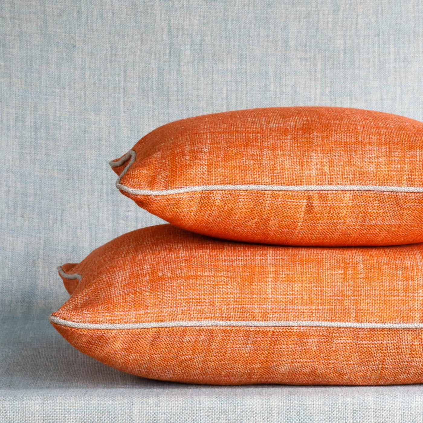 Fermoie cushion stack in Fresco orange fabric linen