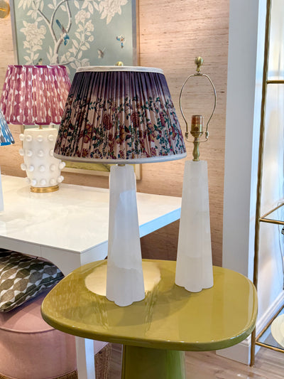 Pair of small alabaster table lamps with pleated shades in showroom setting