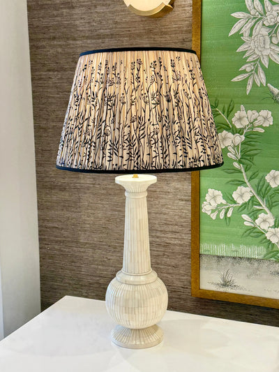Taupe silk lamp shade with black trim on bone lamp