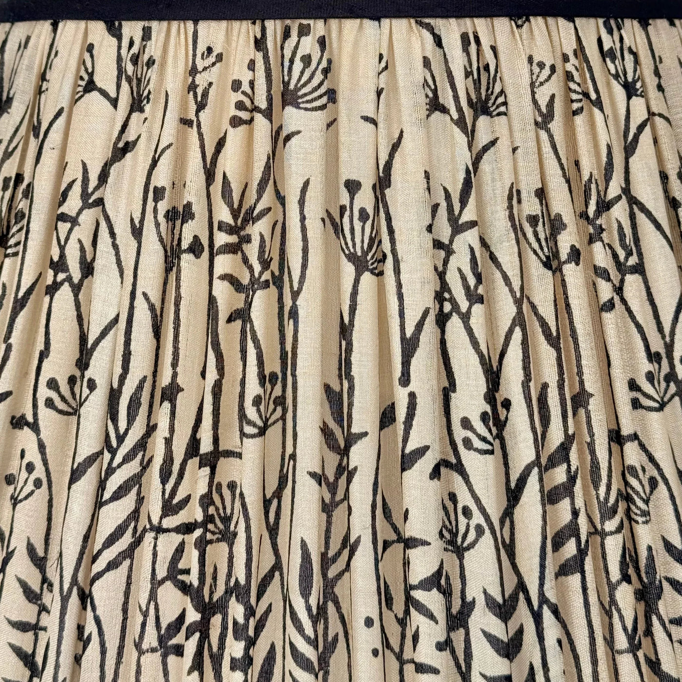 Detail of pleated taupe silk lamp shade with black floral design