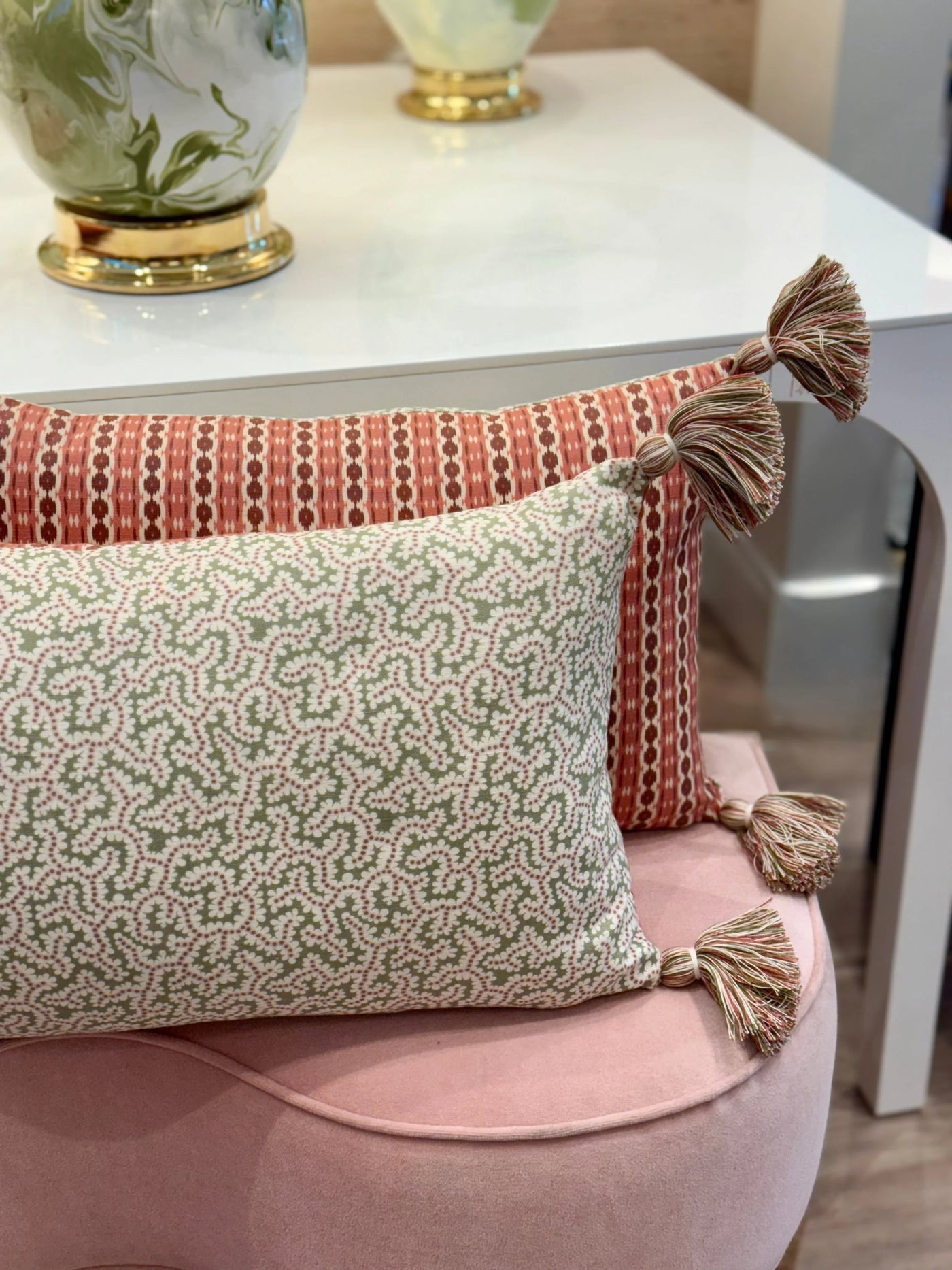 pair of Ian Sanderson Reel Stripe in Red Damson and Elney in Green Bramble Cushions with Red Tassels