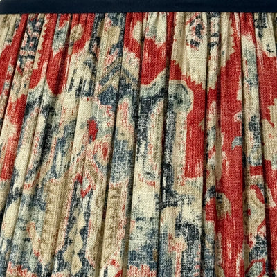 Close-up of a patterned fabric with red, blue, and beige colors.
