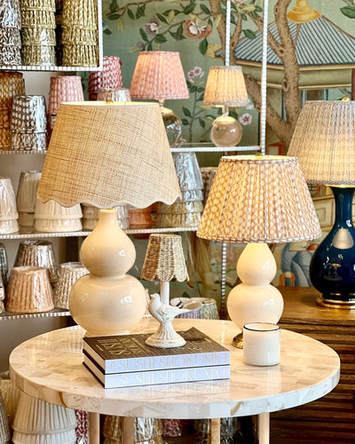 Decorative lamps on a round table with a store display in the background