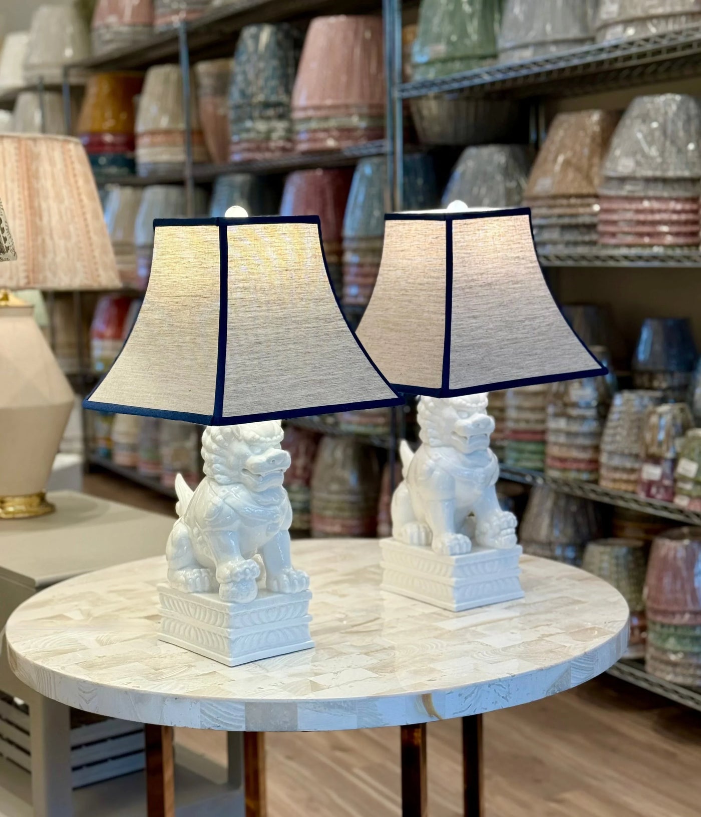 Oatmeal Linen Square Bell Lampshade with Navy Trim paired with Porcelain White Foo Dog Table Lamps