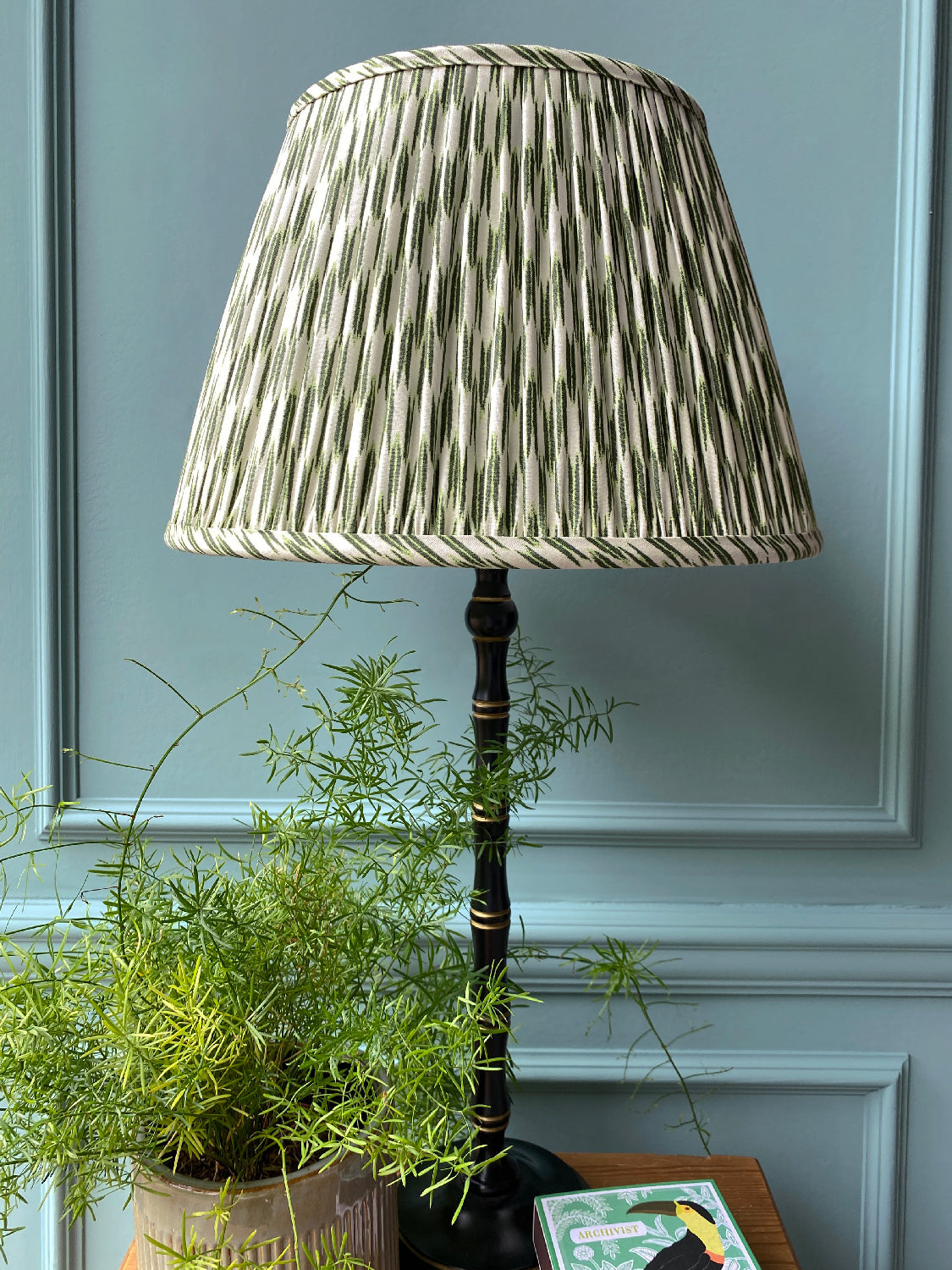 Green and white lampshade on black lamp