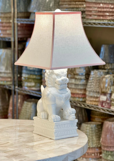 White Linen Square Bell Lampshade with Pink Trim paired with Porcelain White Foo Dog Table Lamp