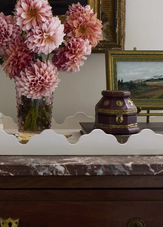 Scalloped white tray on the marble-topped chest