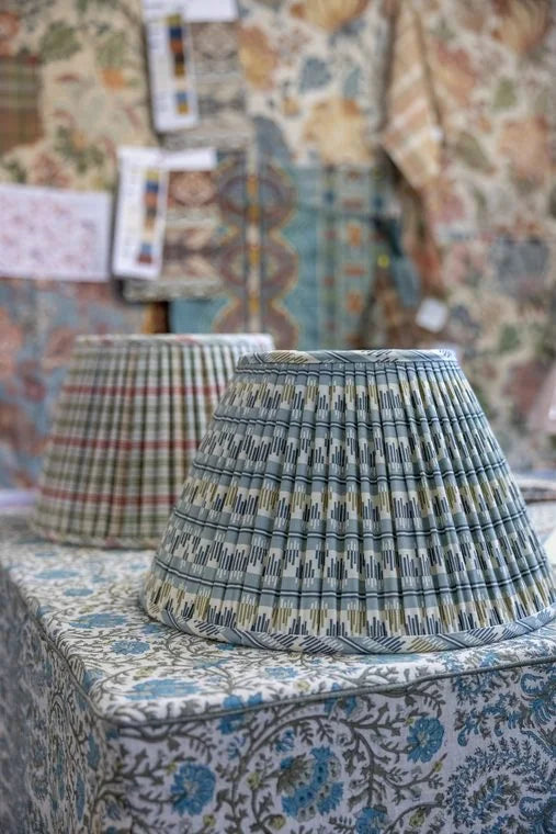 A close view of the pleats on a plaid lampshade, the grid bending with each fold