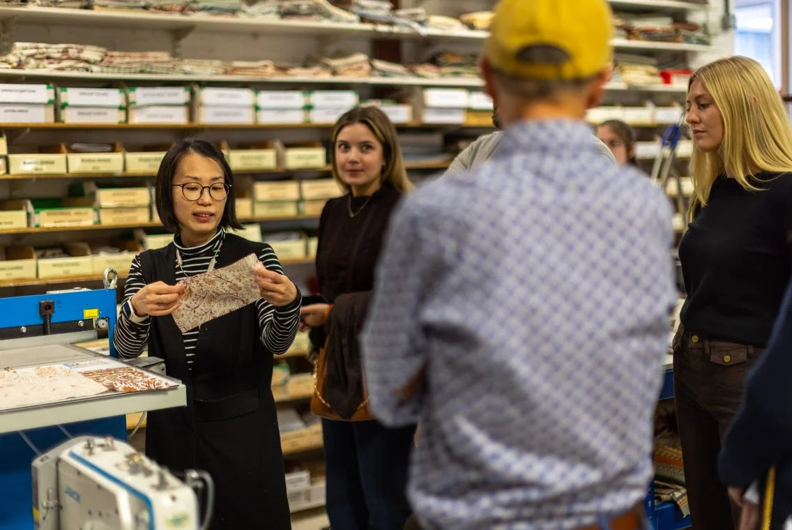 A member of the Ian Sanderson team shows a sample to visitors in front of the swatch drawers