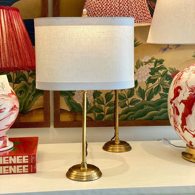Linen banded oval lampshade on a brass lamp
