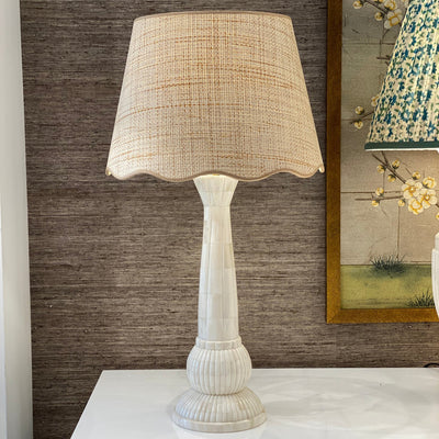 Scalloped raffia lampshade with beige trim on a bone lamp
