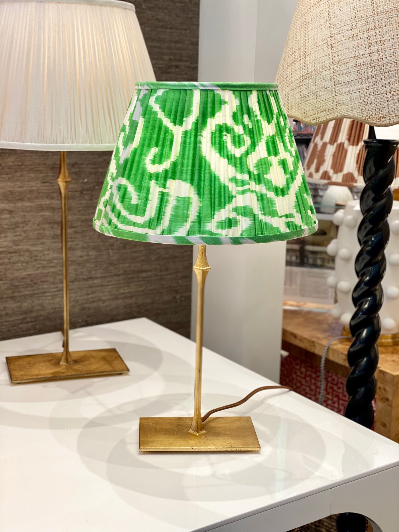 Green and white ikat lampshade on brass bedside lamp